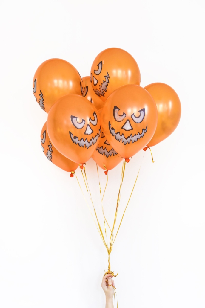 Bouquet de globos naranja con cara de calabaza