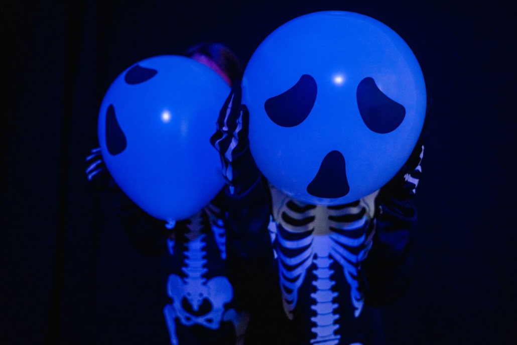 Globos blancos con cara de fantasma bajo luz negra
